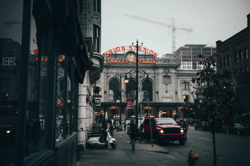 Street view of Denver Union Station with its red neon sign on a foggy day