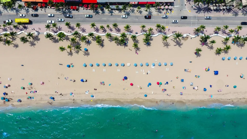 Aerial top-down view of Fort Lauderdale Beach with turquoise water, sand, and umbrellas