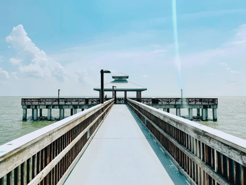 Wooden Fort Myers Beach Pier stretching over the ocean under a blue sky