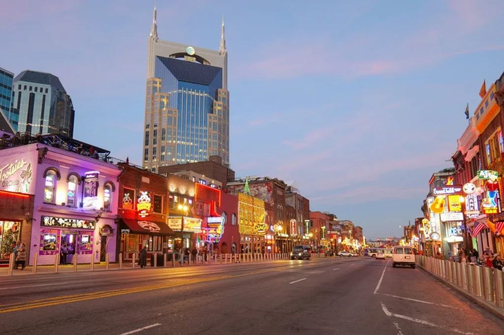 Broadway street in Nashville lined with neon honky-tonk bars under the AT&T building