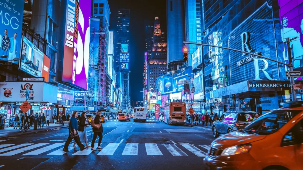 Brightly lit neon billboards and digital screens illuminating Times Square at night