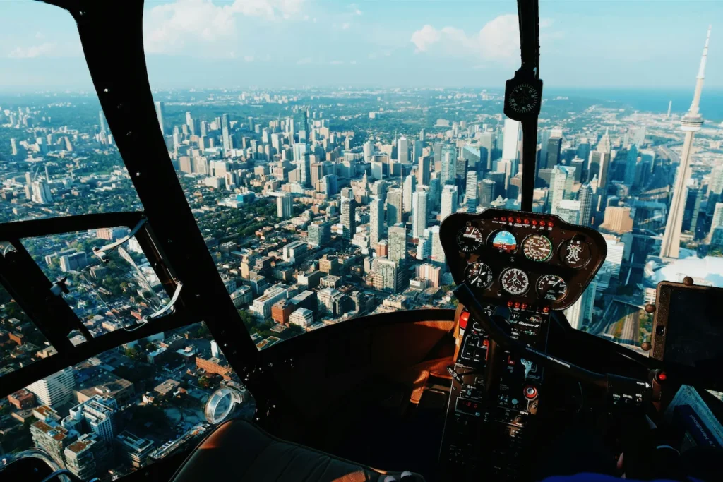 View of Toronto skyline and CN Tower from inside a helicopter cockpit
