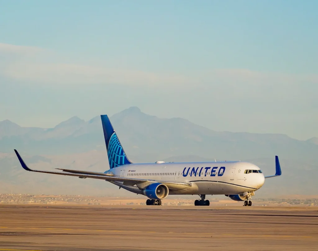 United Airlines passenger plane on the tarmac with mountains in the background