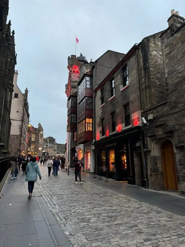 People walking along a cobblestone street near The Witchery by the Castle.