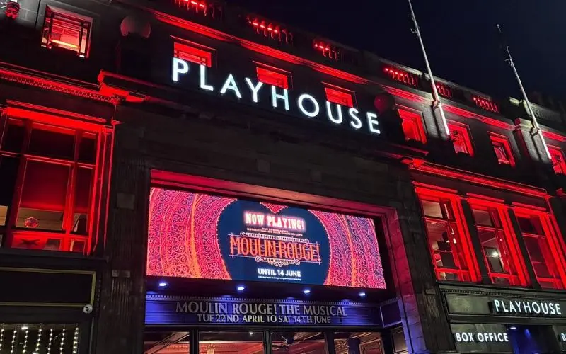The Edinburgh Playhouse lit with red lights at night.