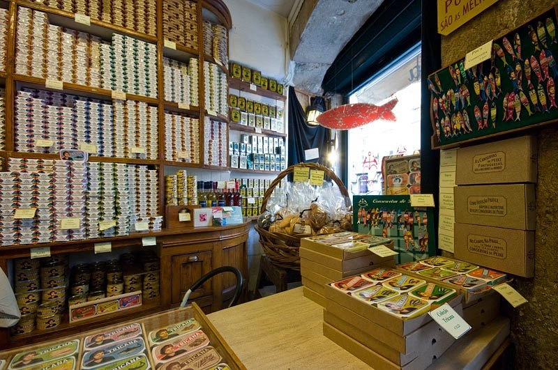Colorful tins of Portuguese canned fish line the traditional wooden shelves at Conserveira de Lisboa.