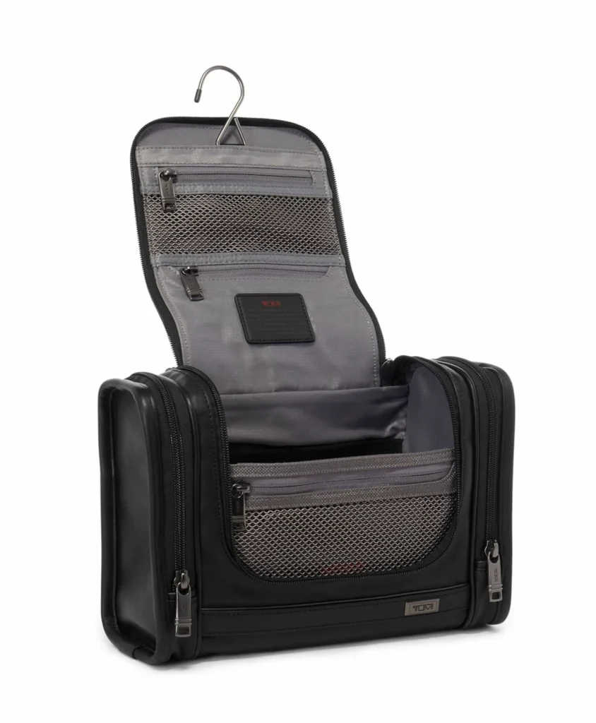 Open black Tumi Alpha 3 hanging toiletry bag with mesh compartments and metal hook
