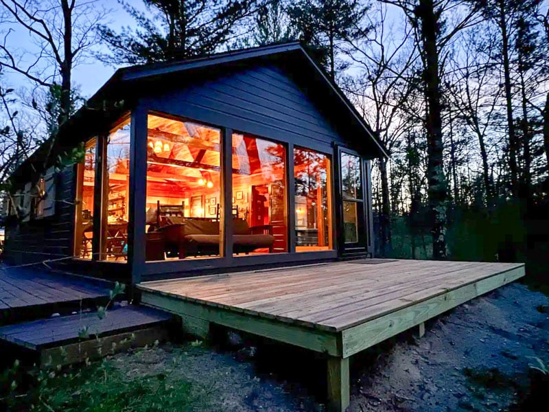 Craftsman Style Cabin features river views and vibrant sunrises through large windows.