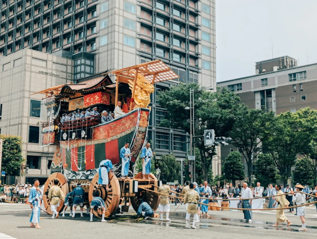 A massive wooden festival float being pulled during the Kyoto Gion Matsuri