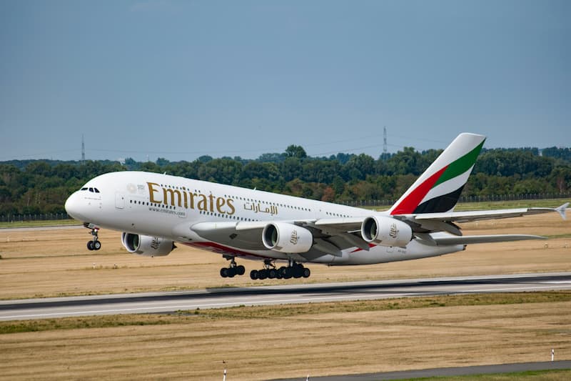 An Emirates Airbus A380 takes off from a runway on a clear day.