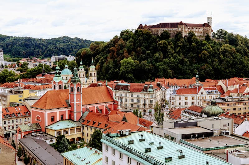 Aerial view of Ljubljana, Slovenia, featuring the castle on a hill and a river flowing through the city.