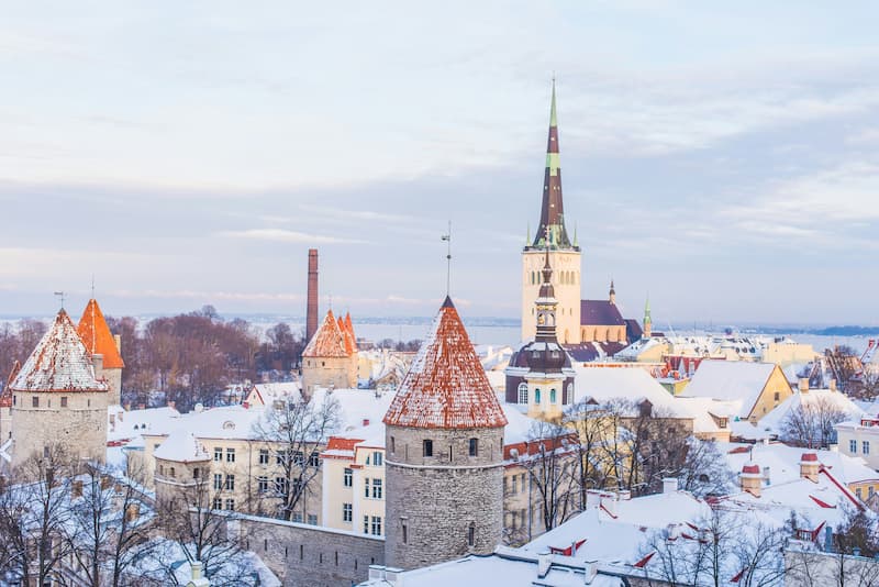 Snow-covered rooftops and medieval towers of Tallinn, Estonia's Old Town, in winter.