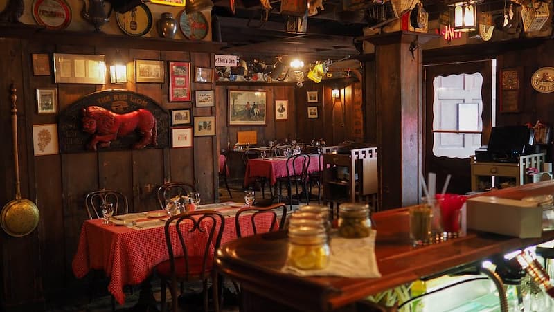 The historic, wood-paneled interior of a tavern decorated with antique memorabilia.
