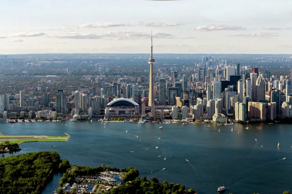 Aerial view of the Toronto city skyline featuring the CN Tower and Rogers Centre over the harbor