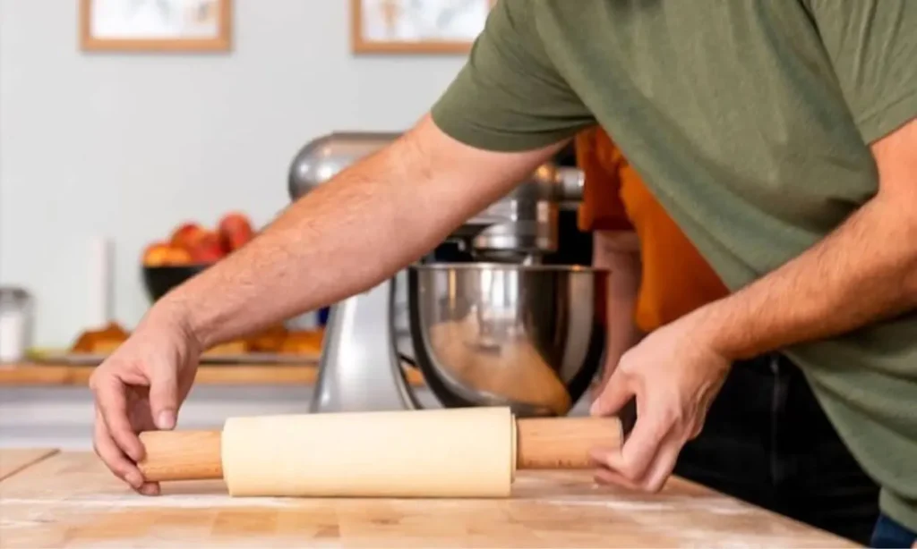 A person rolling out dough with a wooden rolling pin during a baking class at Maison Fleuret.
