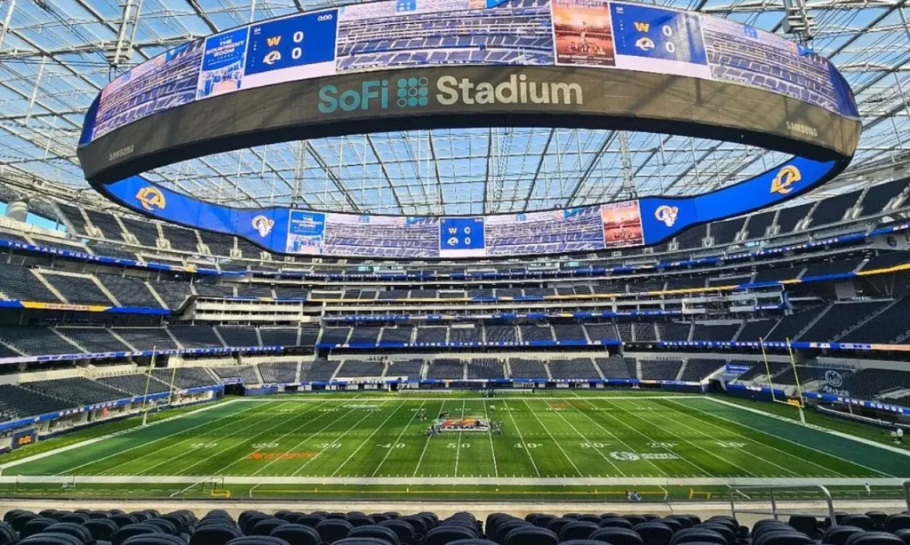 Inside SoFi Stadium showing the field and large circular scoreboard.