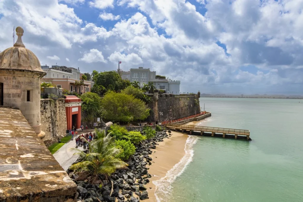 La Fortaleza stone walls and guard tower overlooking a small beach in San Juan, Puerto Rico