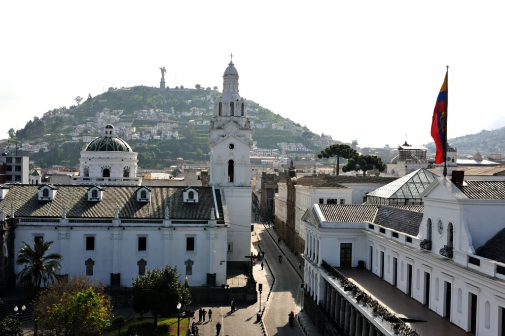 Historic white buildings in Quito's Plaza Grande looking toward El Panecillo hill