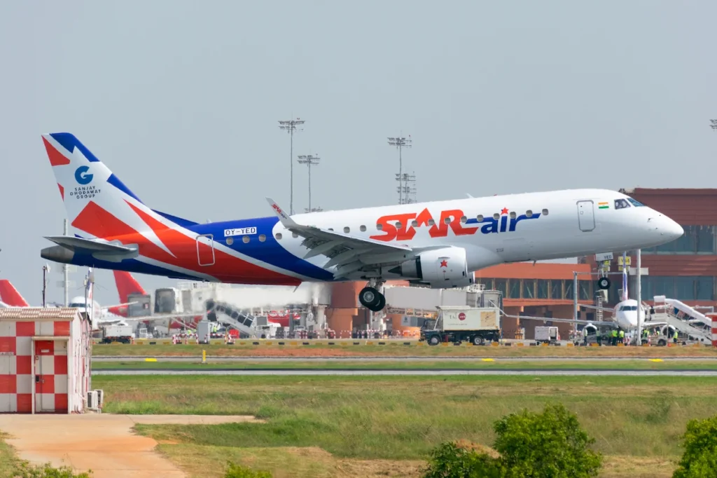 A Star Air Embraer E175 passenger aircraft lifting off from an airport runway