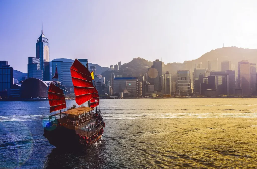 Traditional red-sailed junk boat sailing across Victoria Harbour