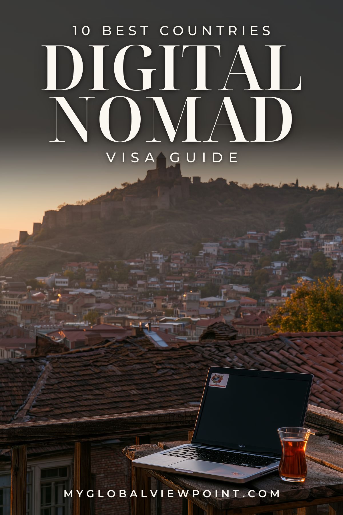 Digital nomad visa guide pin with a laptop and tea on a terrace above Tbilisi's rooftops.